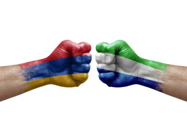 Two hands punch to each others on white background. Country flags painted fists, conflict crisis concept between armenia and sierra leone
