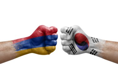 Two hands punch to each others on white background. Country flags painted fists, conflict crisis concept between armenia and south korea