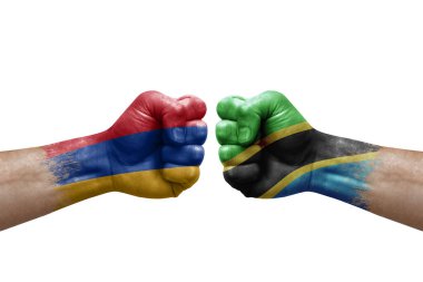 Two hands punch to each others on white background. Country flags painted fists, conflict crisis concept between armenia and tanzania