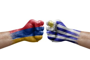 Two hands punch to each others on white background. Country flags painted fists, conflict crisis concept between armenia and uruguay