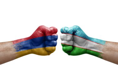 Two hands punch to each others on white background. Country flags painted fists, conflict crisis concept between armenia and uzbekistan