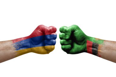 Two hands punch to each others on white background. Country flags painted fists, conflict crisis concept between armenia and zambia