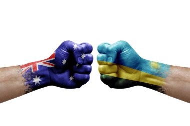 Two hands punch to each others on white background. Country flags painted fists, conflict crisis concept between australia and rwanda