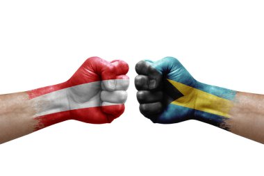 Two hands punch to each others on white background. Country flags painted fists, conflict crisis concept between austria and bahamas