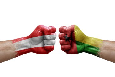 Two hands punch to each others on white background. Country flags painted fists, conflict crisis concept between austria and guinea-bissau