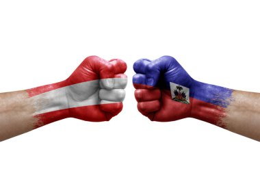 Two hands punch to each others on white background. Country flags painted fists, conflict crisis concept between austria and haiti