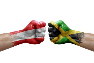 Two hands punch to each others on white background. Country flags painted fists, conflict crisis concept between austria and jamaica