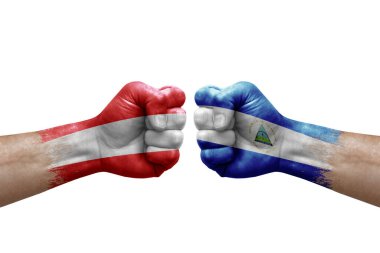 Two hands punch to each others on white background. Country flags painted fists, conflict crisis concept between austria and nicaragua