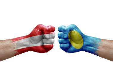 Two hands punch to each others on white background. Country flags painted fists, conflict crisis concept between austria and palau