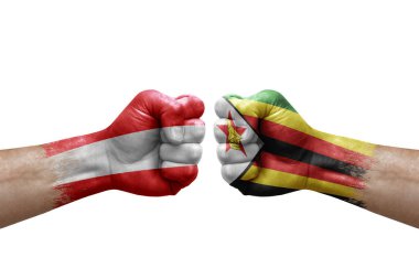 Two hands punch to each others on white background. Country flags painted fists, conflict crisis concept between austria and zimbabwe
