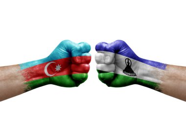 Two hands punch to each others on white background. Country flags painted fists, conflict crisis concept between azerbaijan and lesotho