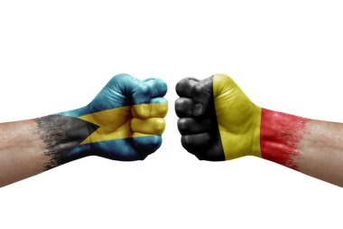 Two hands punch to each others on white background. Country flags painted fists, conflict crisis concept between bahamas and belgium