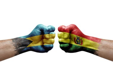 Two hands punch to each others on white background. Country flags painted fists, conflict crisis concept between bahamas and bolivia