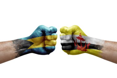 Two hands punch to each others on white background. Country flags painted fists, conflict crisis concept between bahamas and brunei