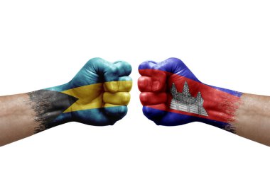 Two hands punch to each others on white background. Country flags painted fists, conflict crisis concept between bahamas and cambodia