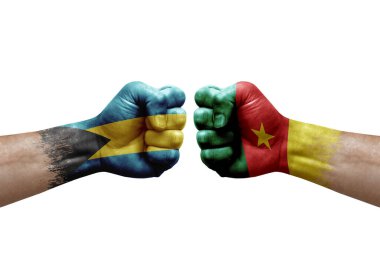 Two hands punch to each others on white background. Country flags painted fists, conflict crisis concept between bahamas and cameroon