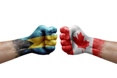 Two hands punch to each others on white background. Country flags painted fists, conflict crisis concept between bahamas and canada