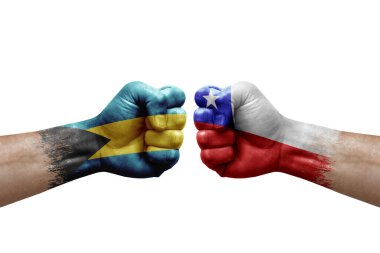 Two hands punch to each others on white background. Country flags painted fists, conflict crisis concept between bahamas and chile