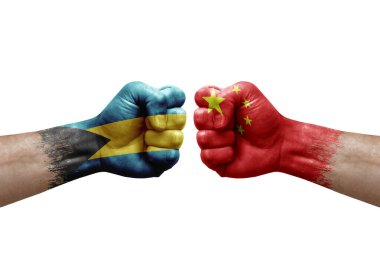 Two hands punch to each others on white background. Country flags painted fists, conflict crisis concept between bahamas and china