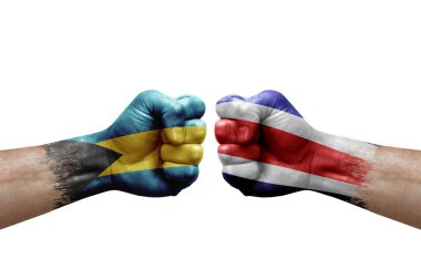 Two hands punch to each others on white background. Country flags painted fists, conflict crisis concept between bahamas and costa rica