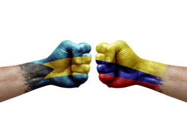 Two hands punch to each others on white background. Country flags painted fists, conflict crisis concept between bahamas and colombia
