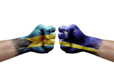 Two hands punch to each others on white background. Country flags painted fists, conflict crisis concept between bahamas and curacao