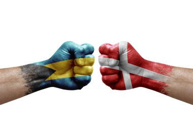 Two hands punch to each others on white background. Country flags painted fists, conflict crisis concept between bahamas and denmark