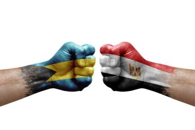 Two hands punch to each others on white background. Country flags painted fists, conflict crisis concept between bahamas and egypt