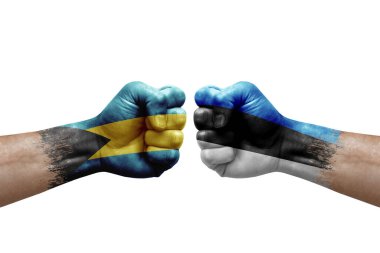Two hands punch to each others on white background. Country flags painted fists, conflict crisis concept between bahamas and estonia