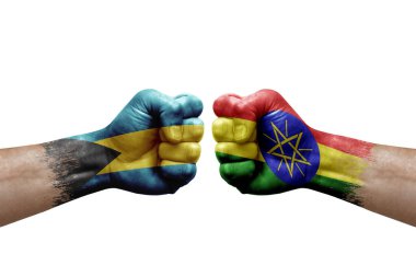 Two hands punch to each others on white background. Country flags painted fists, conflict crisis concept between bahamas and ethiopia