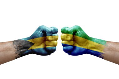 Two hands punch to each others on white background. Country flags painted fists, conflict crisis concept between bahamas and gabon