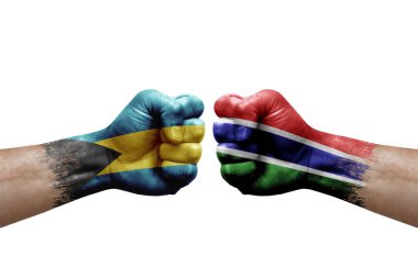 Two hands punch to each others on white background. Country flags painted fists, conflict crisis concept between bahamas and gambia