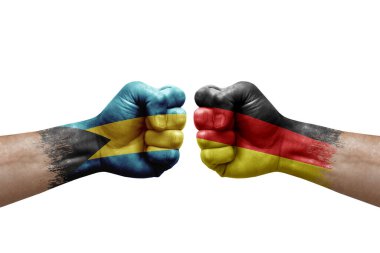 Two hands punch to each others on white background. Country flags painted fists, conflict crisis concept between bahamas and germany