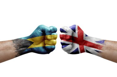 Two hands punch to each others on white background. Country flags painted fists, conflict crisis concept between bahamas and britain