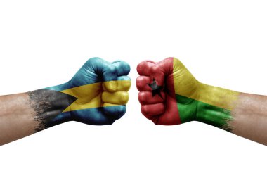 Two hands punch to each others on white background. Country flags painted fists, conflict crisis concept between bahamas and guinea-bissau