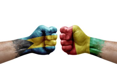 Two hands punch to each others on white background. Country flags painted fists, conflict crisis concept between bahamas and guinea