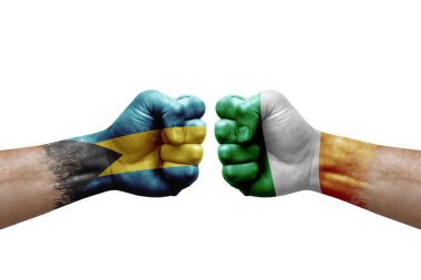 Two hands punch to each others on white background. Country flags painted fists, conflict crisis concept between bahamas and ireland