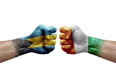 Two hands punch to each others on white background. Country flags painted fists, conflict crisis concept between bahamas and ivory coast