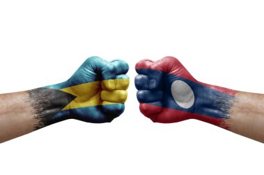 Two hands punch to each others on white background. Country flags painted fists, conflict crisis concept between bahamas and laos