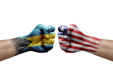 Two hands punch to each others on white background. Country flags painted fists, conflict crisis concept between bahamas and liberia
