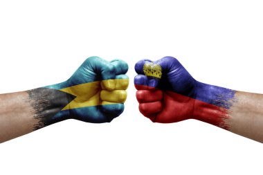 Two hands punch to each others on white background. Country flags painted fists, conflict crisis concept between bahamas and liechtenstein