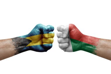Two hands punch to each others on white background. Country flags painted fists, conflict crisis concept between bahamas and madagascar