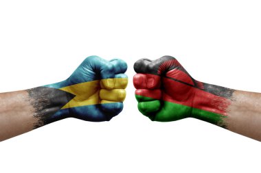 Two hands punch to each others on white background. Country flags painted fists, conflict crisis concept between bahamas and malawi