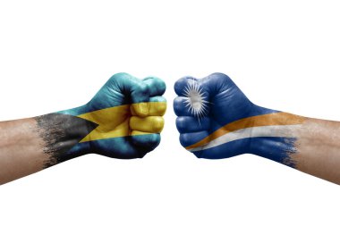 Two hands punch to each others on white background. Country flags painted fists, conflict crisis concept between bahamas and marshall islands