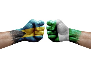 Two hands punch to each others on white background. Country flags painted fists, conflict crisis concept between bahamas and nigeria