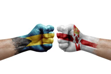 Two hands punch to each others on white background. Country flags painted fists, conflict crisis concept between bahamas and ireland