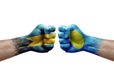Two hands punch to each others on white background. Country flags painted fists, conflict crisis concept between bahamas and palau