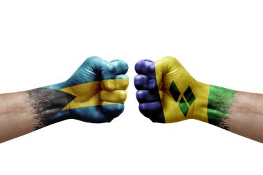 Two hands punch to each others on white background. Country flags painted fists, conflict crisis concept between bahamas and saint vincent and the grenadines