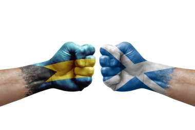 Two hands punch to each others on white background. Country flags painted fists, conflict crisis concept between bahamas and scotland