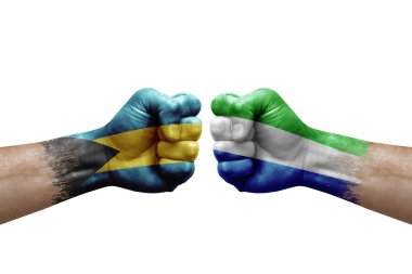 Two hands punch to each others on white background. Country flags painted fists, conflict crisis concept between bahamas and sierra leone